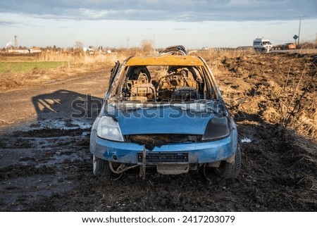 A burned car wreck near to highway Royalty-Free Stock Photo #2417203079