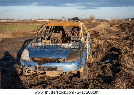 A burned car wreck near to highway Royalty-Free Stock Photo #2417203189