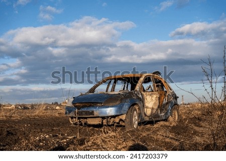 A burned car wreck near to highway Royalty-Free Stock Photo #2417203379