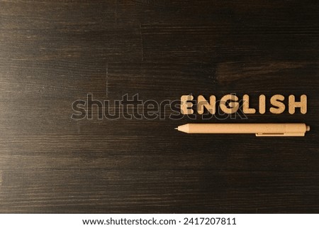 The word "English" and a notebook, the concept of learning English, on a dark background.