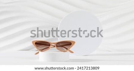 Sunglasses sale banner. Summer sale-out offer. Fashionable beige cat eye frame sunglasses on podium on a white background. Copy space for text. For banner. Optic store discount Royalty-Free Stock Photo #2417213809