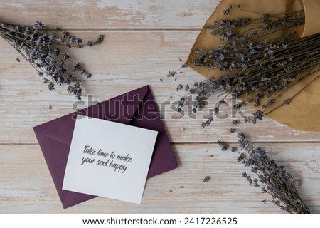 TAKE TIME TO MAKE YOUR SOUL HAPPY text on supportive message paper note reminder from green envelope. Flat lay composition dry lavender flowers. Concept of inner happiness, slowing-down digital detox