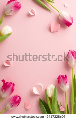 Tulip serenade: Top view vertical snapshot showcasing the beauty of tulips and heart motifs on a delicate pink surface. Plenty of space for personalized expressions or advertising