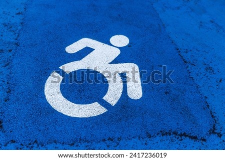horizontal road sign - parking space for a disabled person, image of a man in a wheelchair on a blue background