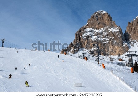 Ski resort in the Dolomites. Mountain recreation place. Ski slopes in the Dolomites on a clear sunny day. Alpine skiing sport and recreation. Royalty-Free Stock Photo #2417238907