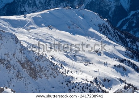 Ski resort in the Dolomites. Mountain recreation place. Ski slopes in the Dolomites on a clear sunny day. Alpine skiing sport and recreation. Royalty-Free Stock Photo #2417238941