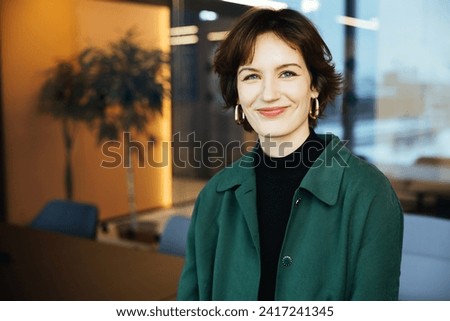 A confident millennial woman showcases her new apartment, symbolizing diversity in a modern office. A close-up profile image captures the gaze of a millennial female Royalty-Free Stock Photo #2417241345