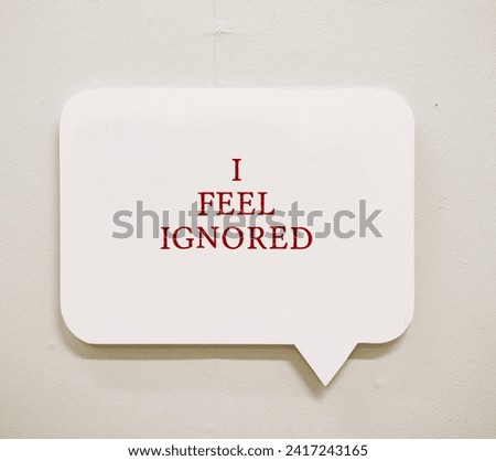 Message on a wall I FEEL IGNORED -  feeling invisible or overlooked by the people around - no one recognize your existence - Experiencing social rejection contribute to invisibility feeling Royalty-Free Stock Photo #2417243165