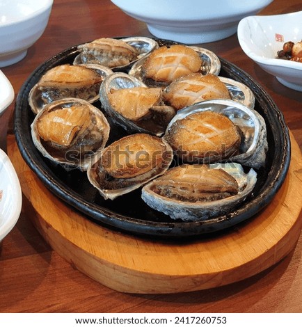 Fresh grilled South Korean abalones Royalty-Free Stock Photo #2417260753