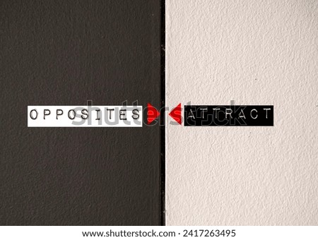 Contrast wall with text written OPPOSITES ATTRACT - means different type of people are often attracted to each other - we are all searching for characteristics we lack Royalty-Free Stock Photo #2417263495