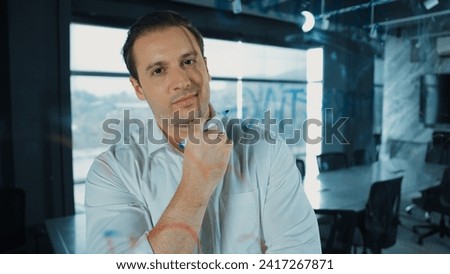 Smart businessman thinking about start up project in front of glass board. Smiling male project manager looking at colorful sticky notes with show creativity marketing strategy. Manipulator.