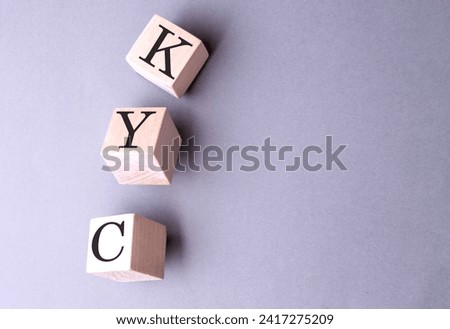 Word KYC on a wooden block on the grey background