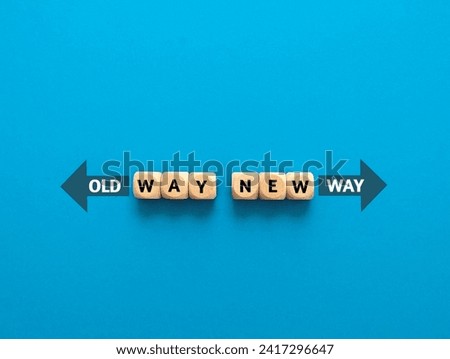 Wooden cube with the word OLD WAY NEW WAY, with arrow on a blue background Royalty-Free Stock Photo #2417296647