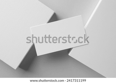 Empty business card and decorative elements on white background, top view. Mockup for design Royalty-Free Stock Photo #2417311199