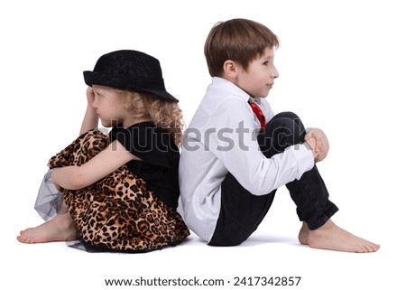 A quarreling little boy and girl are sitting with their backs to each other. Children's grievances