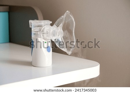 Oxygen mask of nebulizer with steam, medical equipment for pneumonia, covid, sars and bronchitis treatment. Inhaler, respiratory pulmonary disease, child allergy Royalty-Free Stock Photo #2417345003