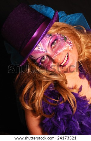 Caucasian woman with Mardi Gras mask painted on her face