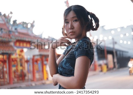 A beautiful young girl at the Chinese New Year festival in Thailand wears a blue cheongsam.