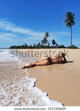 A beautiful athletic girl lies on the beach of Sri Lanka.
