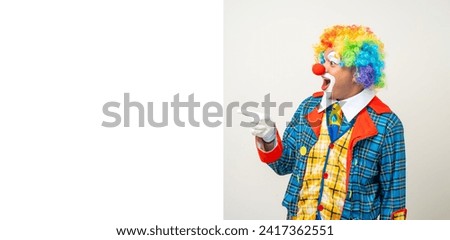 Mr Clown. Portrait of Funny comedian face Clown man in colorful uniform pointing finger to copy space for text advertise. Happy expression amazed male bozo in various pose on isolated background.