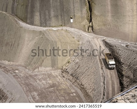 Excavation and embankment work using heavy dump trucks on the Sidan dam project Royalty-Free Stock Photo #2417365519