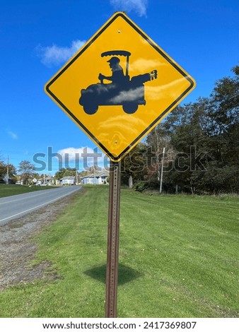 A sign warning pedestrians of golf carts crossing.