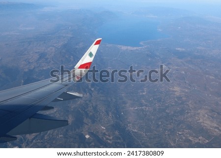Middle East Airlines with the Lebanese flag flying above the mountains. Royalty-Free Stock Photo #2417380809