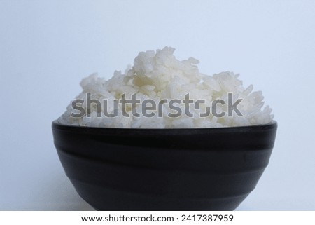 White rice on black bowl, isolated on white background