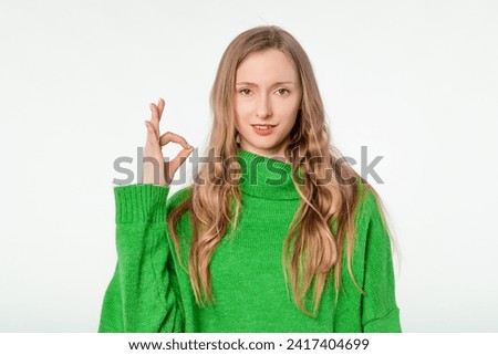 Okay, perfect. Smiling beautiful blonde woman, showing ok, zero gesture, no problem sign, recommending something, standing satisfied against white background