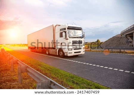 A white modern truck with an isothermal refrigerated semi-trailer transports perishable products in a trailer with a constant temperature regime. Transportation of seafood, fruits and meat.  Royalty-Free Stock Photo #2417407459