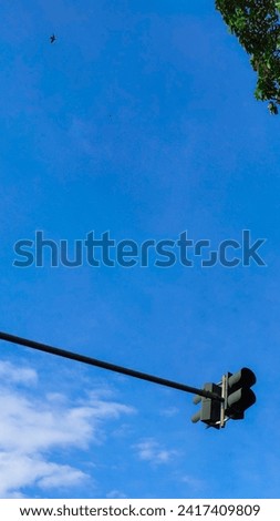 Traffic light in a city against blue sky background