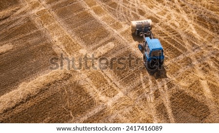 erial view modern agricultural equipment , machinery, tractor  harvests wheat field. seasonal works. drone shot. picture with space for text. Farmland from above
