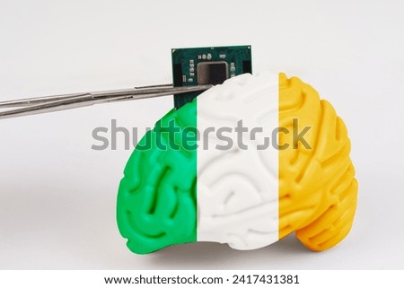 On a white background, a model of the brain with a picture of a flag - Ireland, a microcircuit, a processor, is implanted into it. Close-up