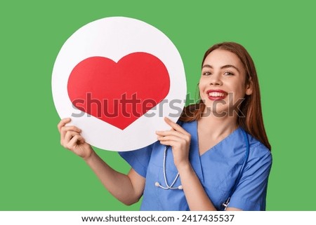 Beautiful young female nurse with heart like icon on green background