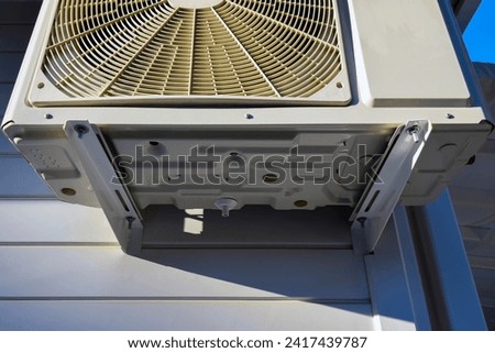 Part of outdoor unit of air conditioner. Dedicated mounting bracket and bolting. Wall mounting. Bottom view. Close-up. Selective focus. Copy space.  Royalty-Free Stock Photo #2417439787