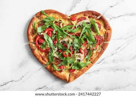 Tasty heart shaped pizza with arugula on white background