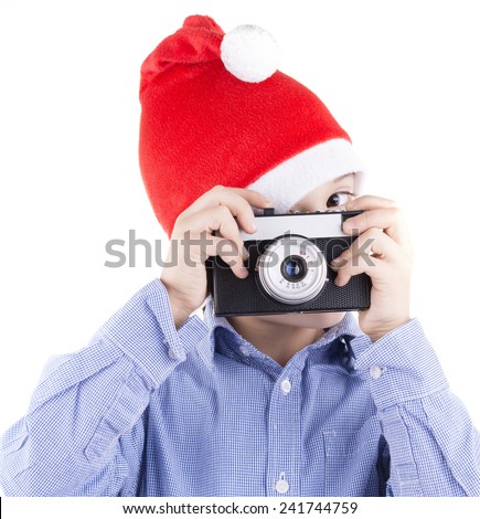  kid with christmas hat shooting with a retro style film camera. close up isolated on white background studio portrait.