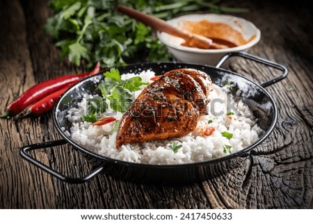 Grilled chicken breast served in a pan with jasmine rice and chili peppers. Royalty-Free Stock Photo #2417450633