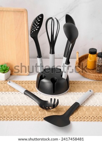 Silicon cooking utensil set including slotted spoon, slotted turner, pasta server, slotted spatula, deep soup ladle, solid spoon, kitchen tongs, egg whisk, basting brush, spreader spatula, hooks, hold Royalty-Free Stock Photo #2417458481