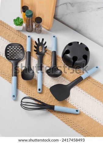 Silicon cooking utensil set including slotted spoon, slotted turner, pasta server, slotted spatula, deep soup ladle, solid spoon, kitchen tongs, egg whisk, basting brush, spreader spatula, hooks, hold Royalty-Free Stock Photo #2417458493