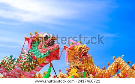 Two colorful Chinese dragon dance performances against blue sky background during Chinese New Year celebrate festival Royalty-Free Stock Photo #2417468721