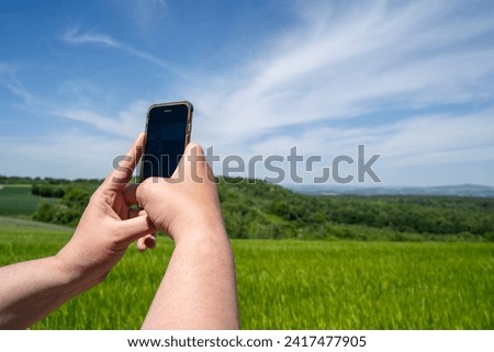 Man takes a photo of the landscape with his cell phone