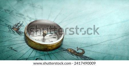 Magnetic old compass on world map. Travel, geography, history, navigation, tourism and exploration concept background. Retro compass on geography map. Royalty-Free Stock Photo #2417490009