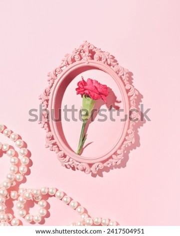 Portrait of a red carnation in an oval romantic picture frame, an elegant, feminine floral composition.