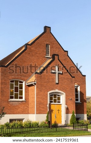Christian church building exterior, cross sign on facade wall.
