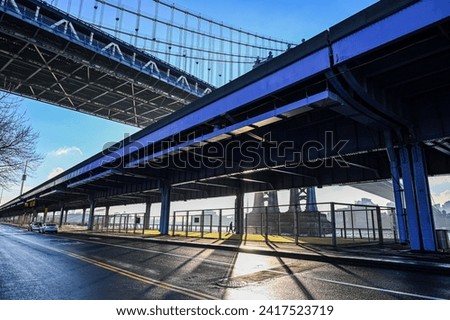 Early morning sunrise casting shadows underneath a large X formed by the FDR overpass and Manhattan bridge in the lower east side of new york city