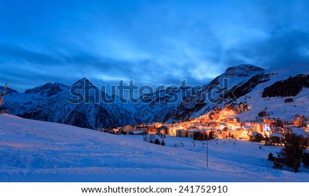 Photo of France ski resort Les Deux Alpes at the evening. You can see a part of resort with many mountains around it.