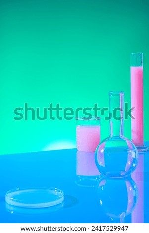 Vertical frame with laboratory concept for advertising product. Boiling flask, test tube, beaker and petri dish filled with pink liquid decorated on green gradient background Royalty-Free Stock Photo #2417529947