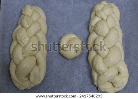 Homemade challahs for Shabbat before putting them in the oven, a Jewish custom of baking challahs on Friday in honor of the Holy Shabbat Royalty-Free Stock Photo #2417548295