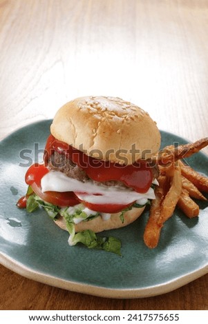close up photo of a ham burger on a plate and it looks very tempting